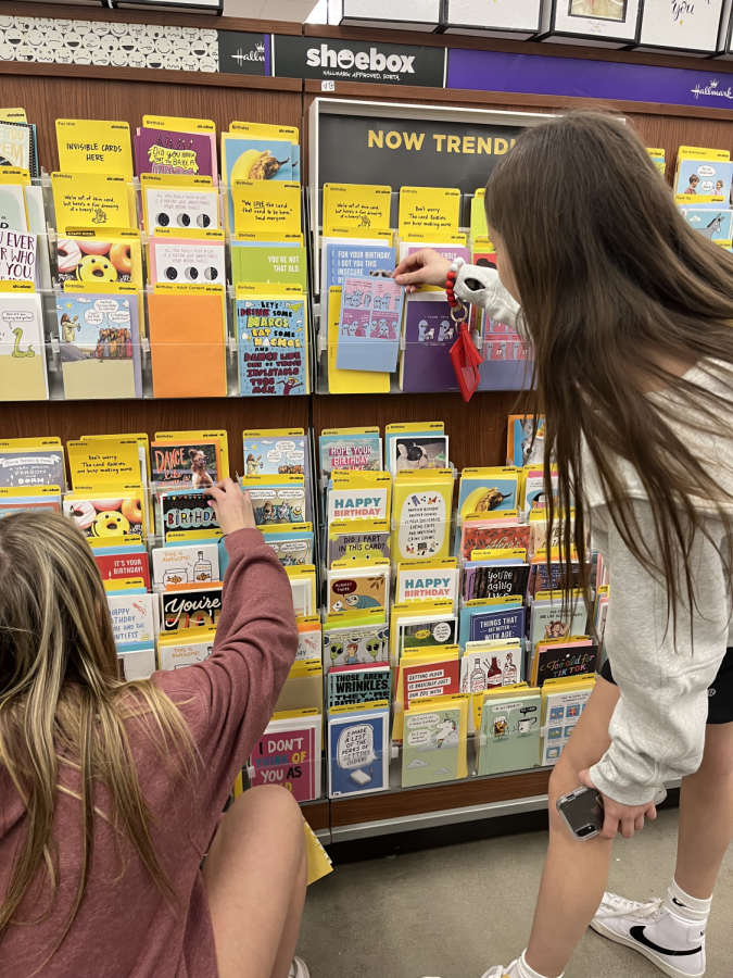 Freshmen Bree Papp and Avery Moore browse cards for holiday gifts.