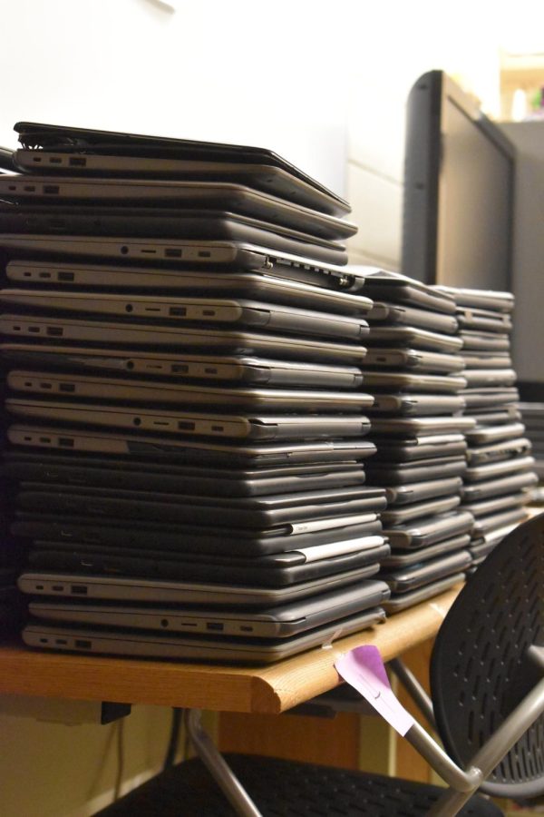 Stacks of Chromebooks in need of repair.