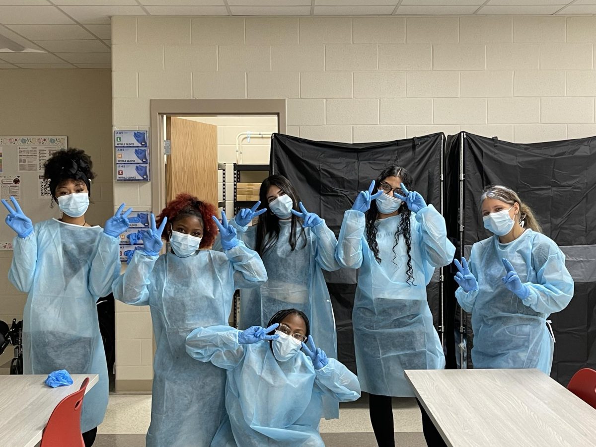 Students practice putting on their PPE