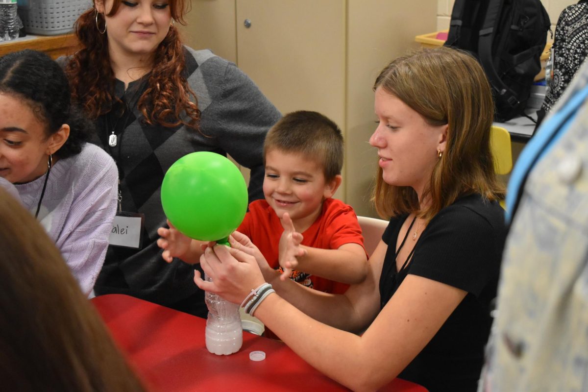 Allison Wooters (10) shows a Little Bulldog what happens when baking soda is mixed with vinegar.