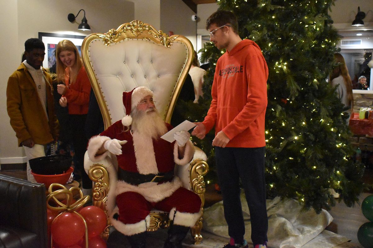 Student hands his finished letter to Santa.