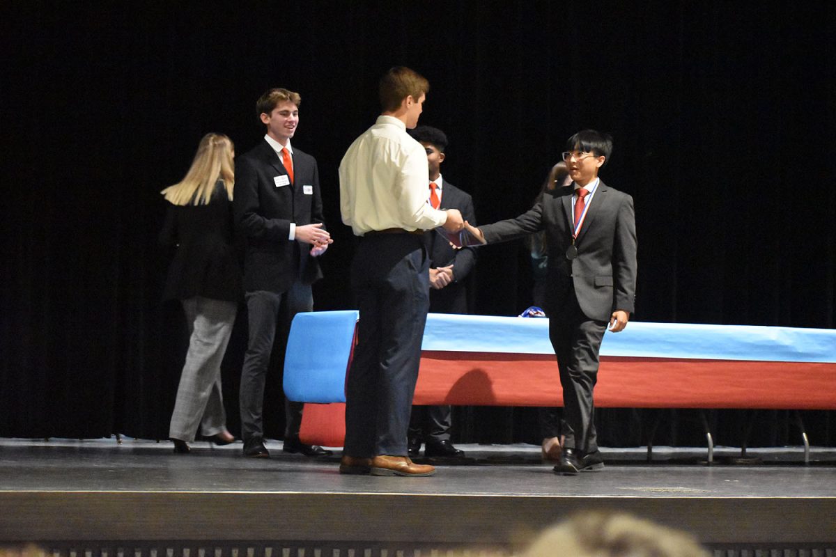 Cesar Querimit (11) receives an award for his Health Research Presentation event. 