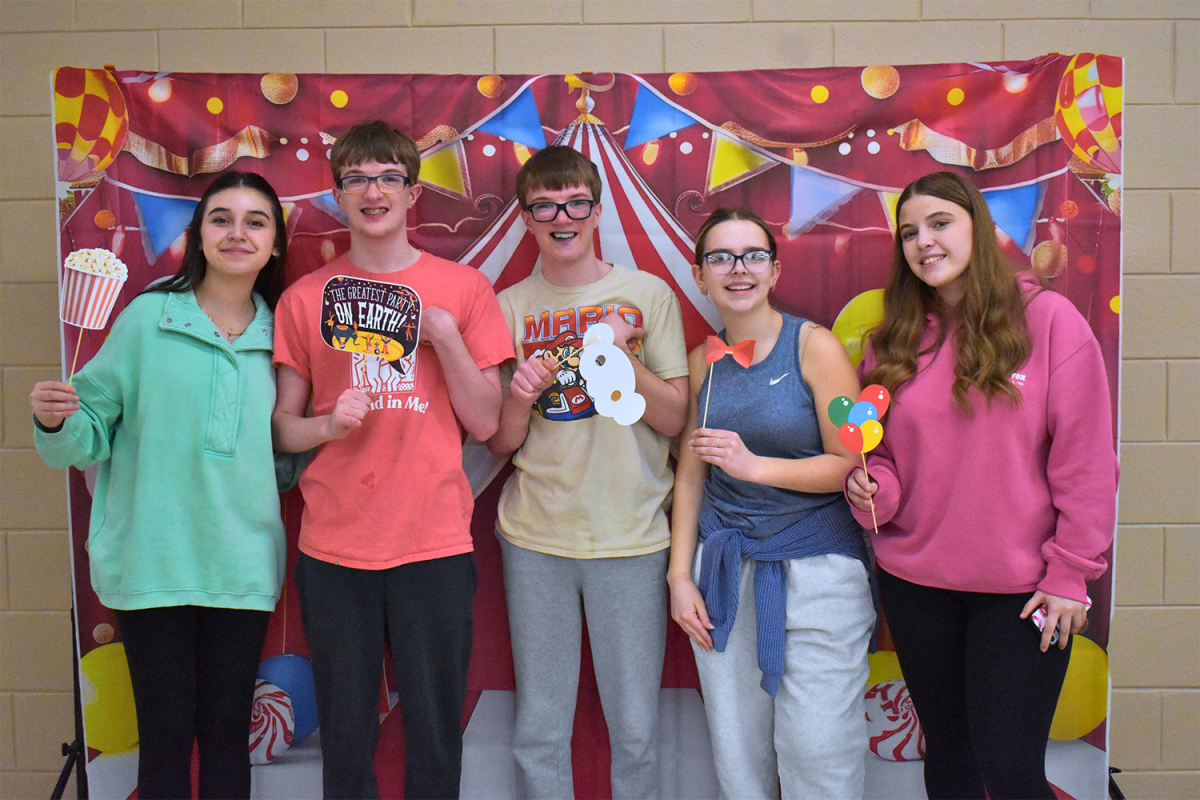 A group of Best Buddies pose for a picture with masks and signs.