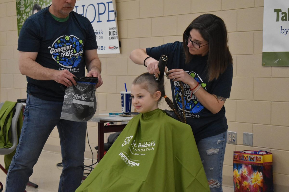 A student gets their head shaved for St. Baldricks.