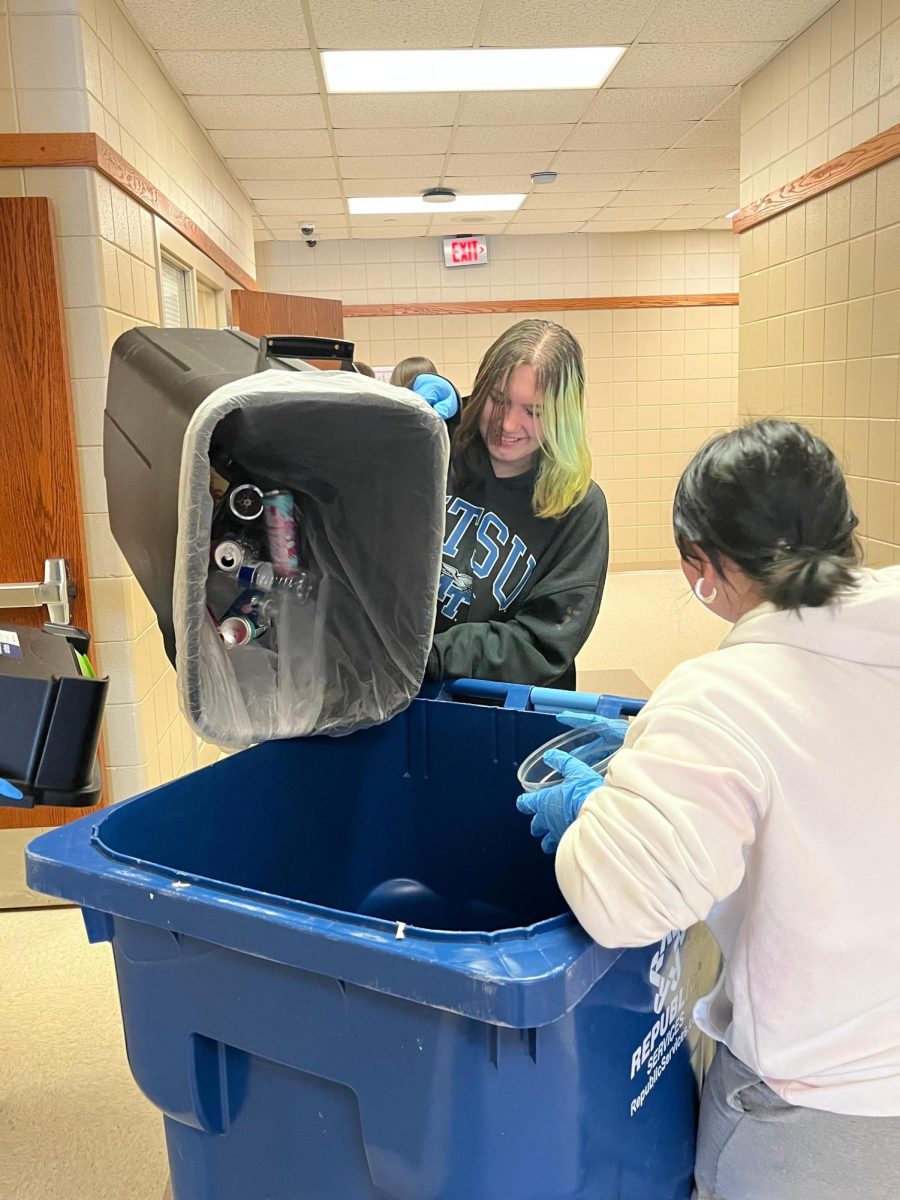 Green machine student takes out recycling. 