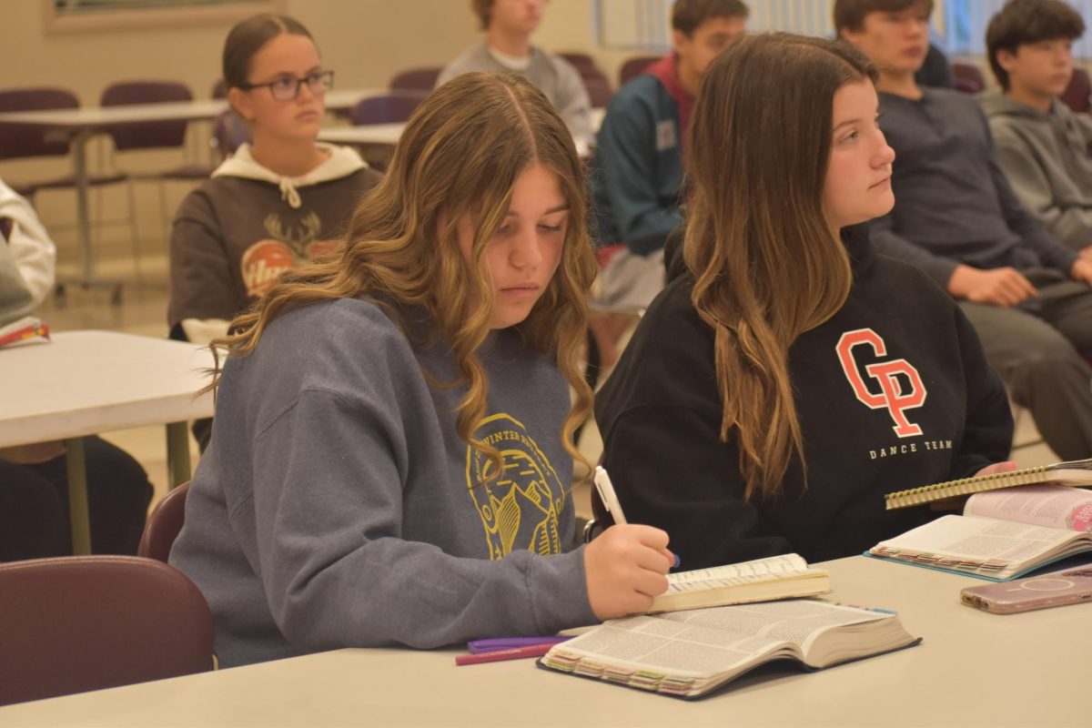 Amelia Buckner (9) highlights the verse the speaker is talking about.