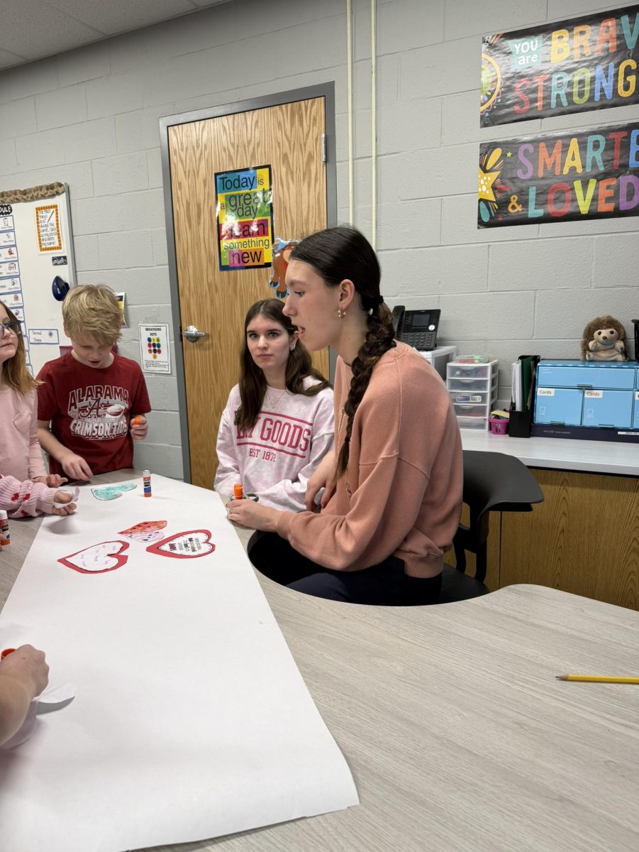 Lily Bajda (10) and Evelyn Noak (10) guide Lake Street first graders during a visit for The C.U.R.E