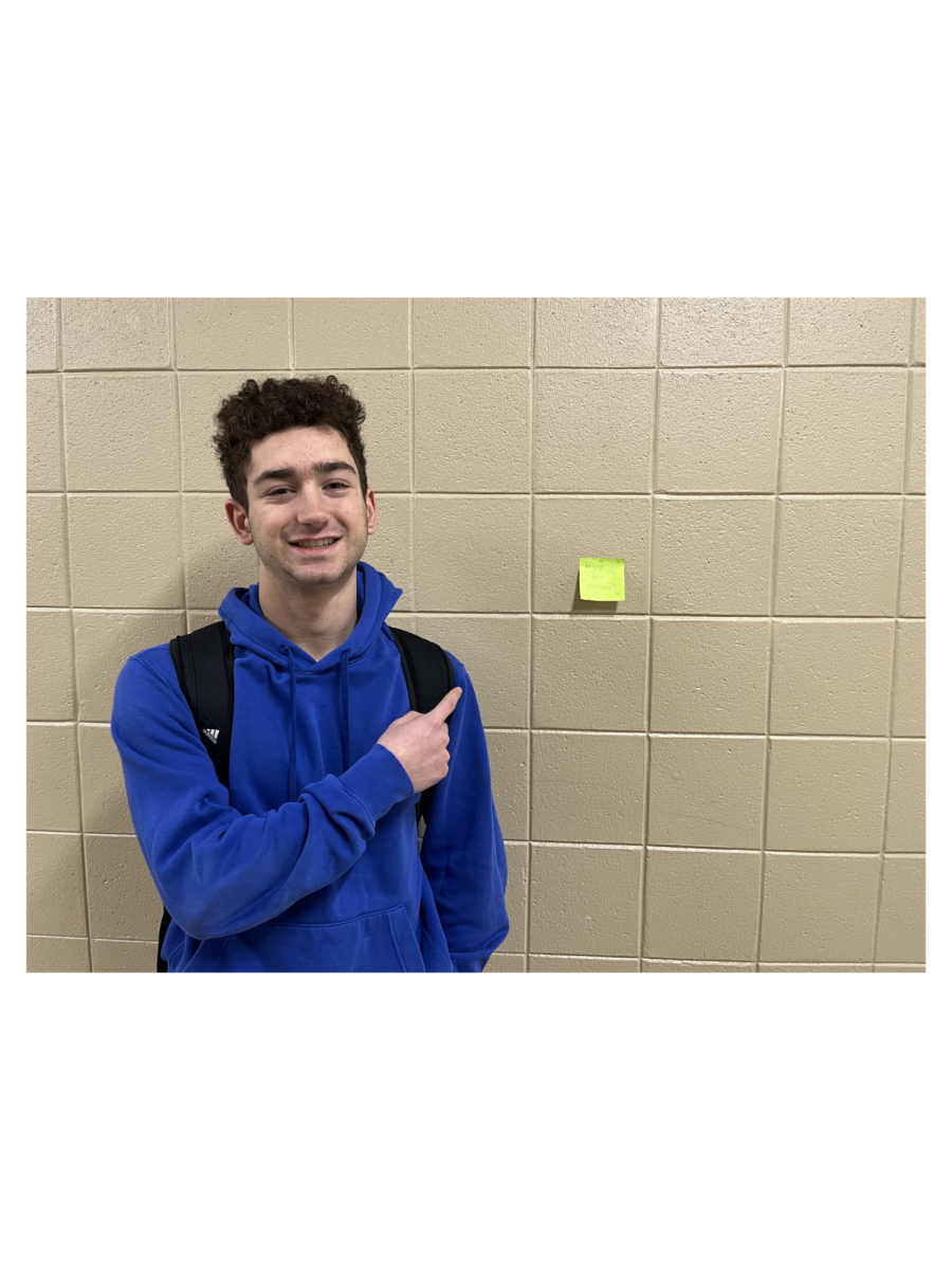 Member of The Cure club, Luca Rodrigue, poses in front of a Post-It note with a kind message.