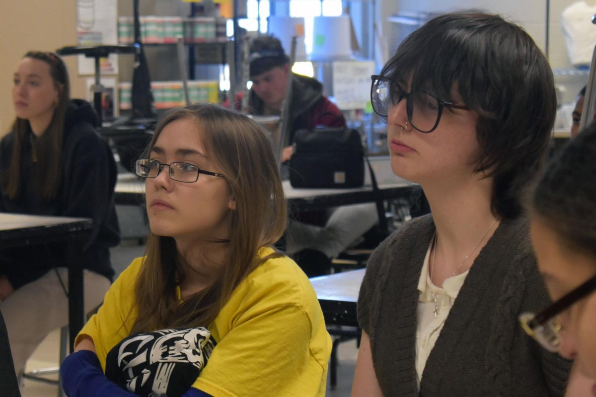 Madelyn Jefferson (11) and Nole Robinson (11) watch Mrs. Quinn debrief for the NAHS meeting.