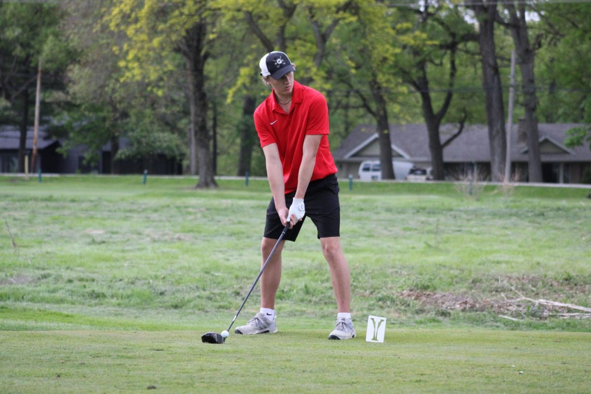 Ryan Prendergst (11) lines up his shot before he hits the golf ball.