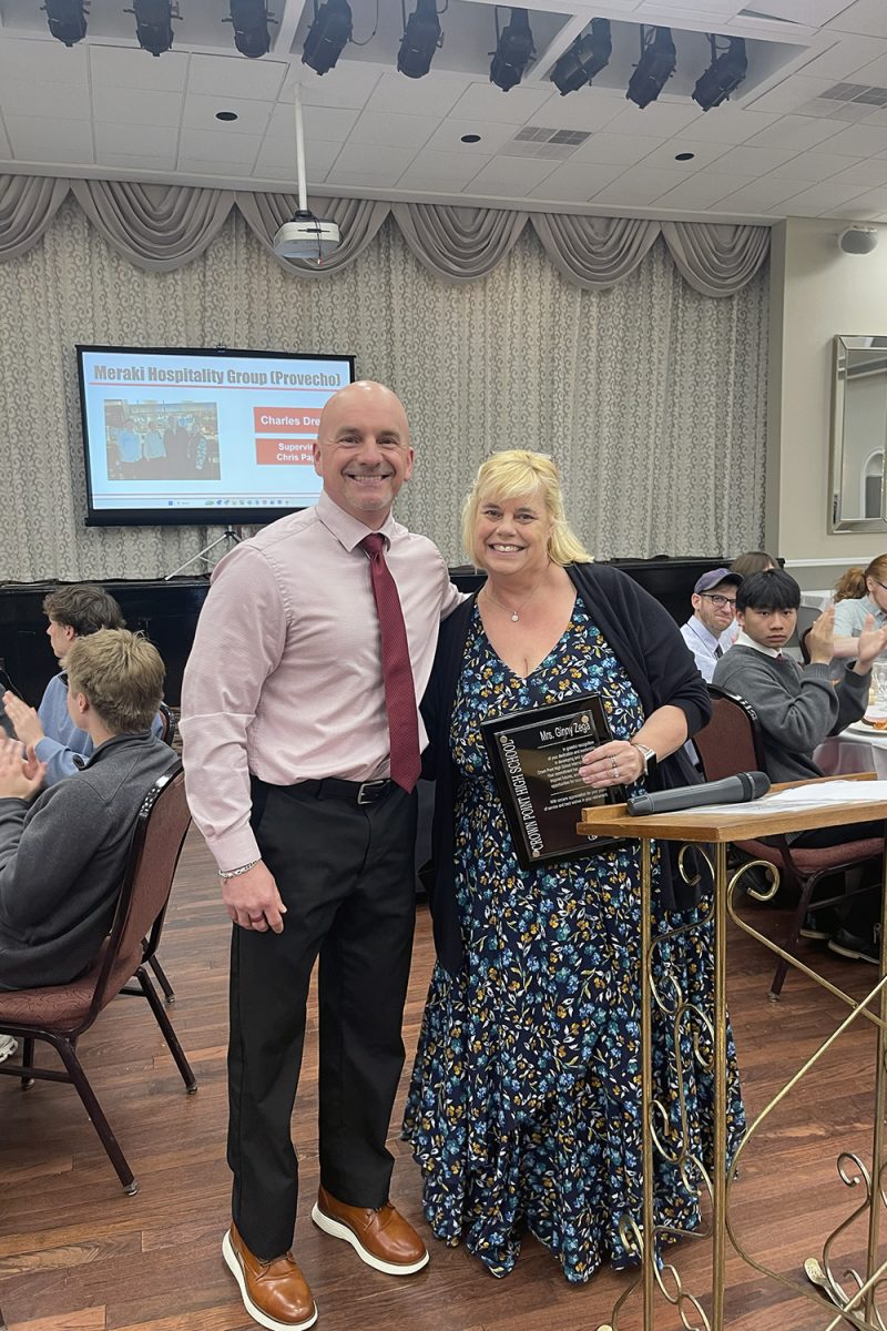 Principal Russ Marcinek presents Ginny Zega with a plaque.